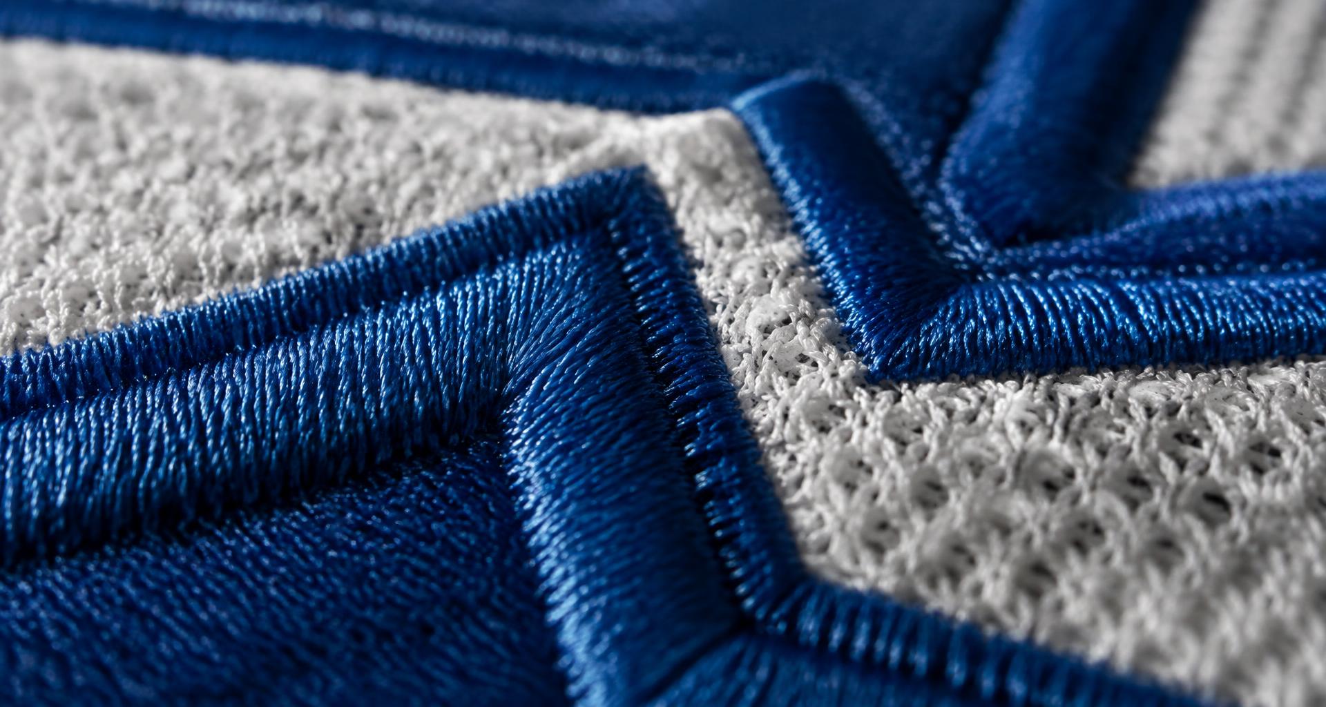 Close-up of raised blue embroidery on hockey mesh